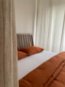 a bed with orange pillows in a bedroom at Bytík pod Tatrami - Svit in Svit