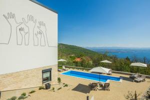 a building with a mural of hands on the side at Villa Manus - Boutique Apartments in Lovran