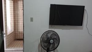 ein Badezimmer mit einem Ventilator und einem Fernseher an der Wand in der Unterkunft Casa no Bairro da Prata, para até 8 pessoas, 150mt do PP in Campina Grande
