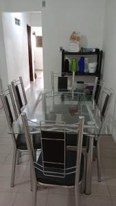 ein Glastisch mit Stühlen in einem Zimmer in der Unterkunft Casa no Bairro da Prata, para até 8 pessoas, 150mt do PP in Campina Grande + 6 Fotos