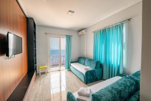 a hotel room with a bed and a couch and a window at Vila e Bardhe Butique Hotel in Sarandë