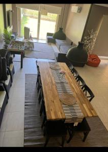 a wooden table and chairs in a living room at فيلا 5 نجوم بجاردن خاص راحة وفخامة في مكان واحد in El Alamein