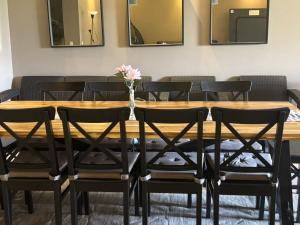 a wooden table with black chairs and a vase with flowers at فيلا 5 نجوم بجاردن خاص راحة وفخامة في مكان واحد in El Alamein +14 photos