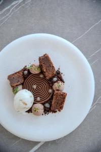 a white plate with a piece of cake and ice cream at Hôtel La Villa Douce in Rayol-Canadel-sur-Mer