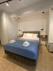 a bedroom with a bed with two towels on it at Villa Nickolas in Paleo Tsifliki