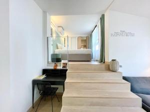 Eine Treppe führt zu einem Schlafzimmer mit einem Bett und einem Schreibtisch. in der Unterkunft PARISIAN HOME l MONTMARTRE in Paris