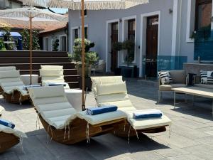 a group of lounge chairs and umbrellas on a patio at Boutique 17B in Sibiu