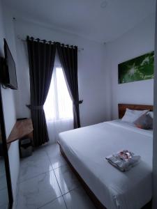 une chambre avec un grand lit et une fenêtre dans l'établissement Rayana Resort, à Songgoriti