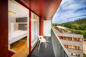 ein Balkon mit einem Schlafzimmer, einem Bett und einem Tisch in der Unterkunft Omnia Hotel Relax & Wellness in Janské Lázně