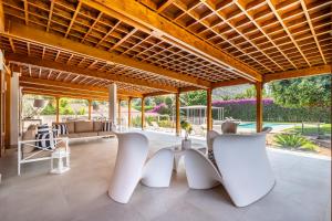 an outdoor living room with white chairs and a wooden ceiling at Il Giardino di Venere in Mondello