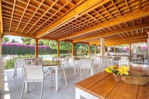 a restaurant with white chairs and tables and a wooden ceiling at Il Giardino di Venere in Mondello