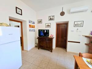 ヴィッラピアーナにあるVillapiana Milano Home by Holiday Worldのリビングルーム(冷蔵庫、テレビ付)