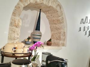 a shelf with vases and a statue on a wall at Romantic Corner in Alberobello