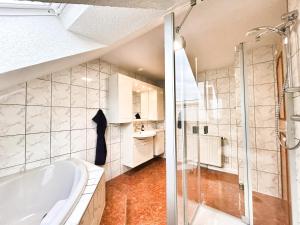 a bathroom with a tub and a glass shower at Ferienhaus Landeskrone in Dresden +23 photos