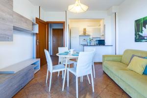a living room with a table and chairs and a couch at Appartamento Oleandro - MyHo Casa in Villa Rosa