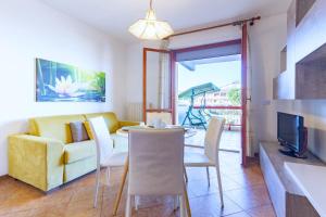 a living room with a couch and a table with chairs at Appartamento Oleandro - MyHo Casa in Villa Rosa
