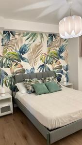 - une chambre avec un grand lit et du papier peint tropical dans l'établissement Villa Adriana, à Fleri