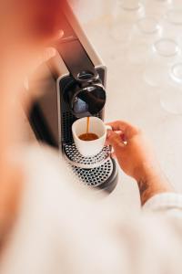 a person holding a cup of coffee in front of a computer at beppo Restaurant Boutique-Hotel in Backnang