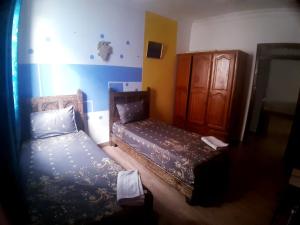 a small bedroom with a bed and a cabinet at Dar yahya in Chefchaouen