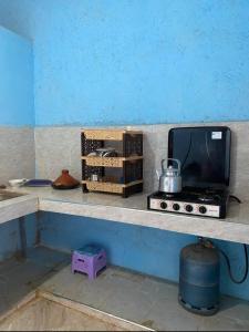una encimera con microondas y TV. en Housse stander merzouga, en Merzouga