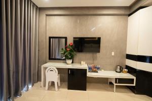a room with a desk with a vase of flowers at Ngoc Se Hotel in Pleiku