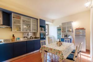 a kitchen with blue cabinets and a table with chairs at Felciolina - Medieval Country House in Troghi +16 photos