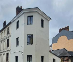 un edificio blanco con una chimenea encima en Appartement typique Rouen centre tout confort, en Rouen