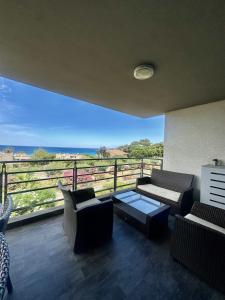 a balcony with couches and a view of the ocean at Apartment with sea view and access in LʼÎle-Rousse +7 photos