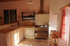 una cocina con fregadero y estufa horno superior en Gîte du Grand Sourel, sa vue et son jardin, en Moissac-Vallée-Française 27 fotos más