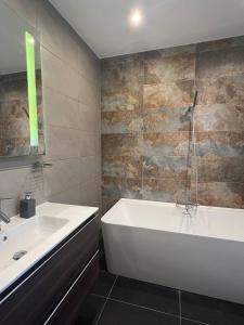 Un baño con bañera blanca y lavabo. en Front Row Malta - Your Grand Harbour Home with Rooftop Terrace & Views of Valletta, en Kalkara 19 fotos más