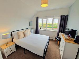 a bedroom with a white bed and a window at The Kensington in Great Yarmouth