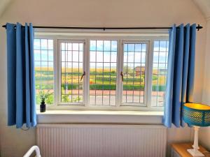a window with blue curtains in a room at The Kensington in Great Yarmouth