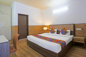 a hotel room with a large bed and a desk at FabExpress Vasant Villa - Near ILBS Hospital in New Delhi