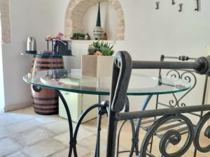 a glass table and a chair in a kitchen at Romantic Corner in Alberobello