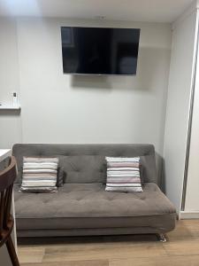 グアルーリョスにあるAeroporto GRU e Shopping Maia, com Ar Condicionadoのソファ、薄型テレビが備わる客室です。