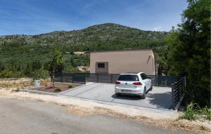 ein weißes Auto auf einem Parkplatz vor einem Haus geparkt in der Unterkunft 2 Bedroom Beautiful Home In Kremena in Kremena + 28 Fotos