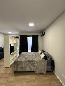 ein Schlafzimmer mit einem großen Bett und einem Fernseher in der Unterkunft MOVISTAR ARENA a 2 CUADRAS PREMIUM !!!! in Buenos Aires