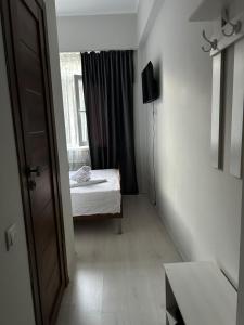 a small room with a bed and a window at Айымхан in Almaty