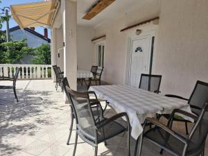 a dining table and chairs on a patio at Guest House Keskic in Karlobag
