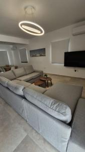 un soggiorno con divano e TV a schermo piatto di Nadine sea side villas a Larnaka Altre 55 foto
