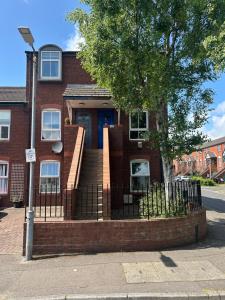 a brick house with a fence in front of it at Tourist board certified Super city centre apartment with free parking in Belfast