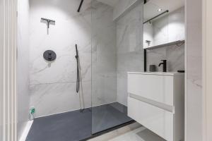 a white bathroom with a shower and a sink at Beau Soleil in Ostend +24 photos