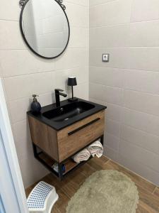 ein Badezimmer mit einem schwarzen Waschbecken und einem Spiegel in der Unterkunft Villa Green House in Tscherweni Breg