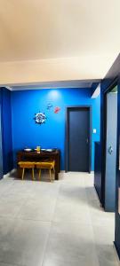 a room with a bench and a blue wall at Studio 3 Praias in São Vicente