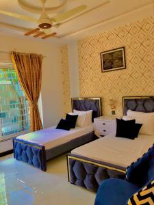 ein Schlafzimmer mit zwei Betten und einem Fenster in der Unterkunft Luxury Family Apartment in Islamabad