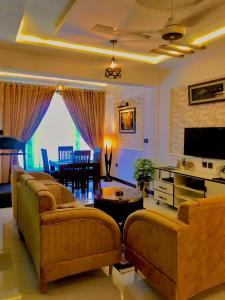 ein Wohnzimmer mit zwei Sofas und einem Tisch in der Unterkunft Luxury Family Apartment in Islamabad