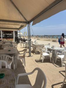 a group of tables and chairs on the beach at Casa vacanza da Sandro in Priolo Gargallo