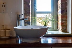 ein Spülbecken auf einer Theke mit Fenster in der Unterkunft Foxes Den at Tove Valley Cottages in Towcester + 5 Fotos