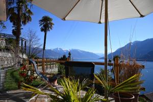 a bird sitting in a chair under an umbrella at Casa Lago Azzurro Atelier in Cannobio +16 photos