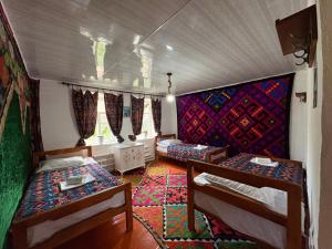 a room with two bunk beds and a rug at Kochmon guesthouse in Naryn